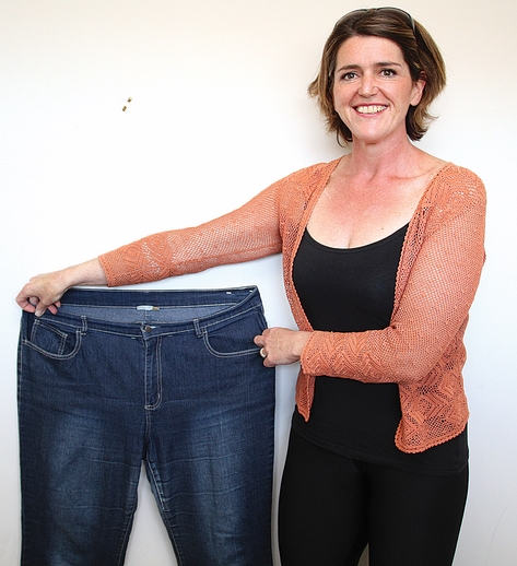 Julie Redwood after losing 50kg and with her old jeans. Photo: Andrew Board.