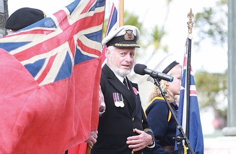 Retired captain Tom Rowling looks at a “Red Duster”, a Merchant Navy flag, during the Merchant Navy Parade at Anzac Park on Saturday morning. Photo: Andrew Board.
